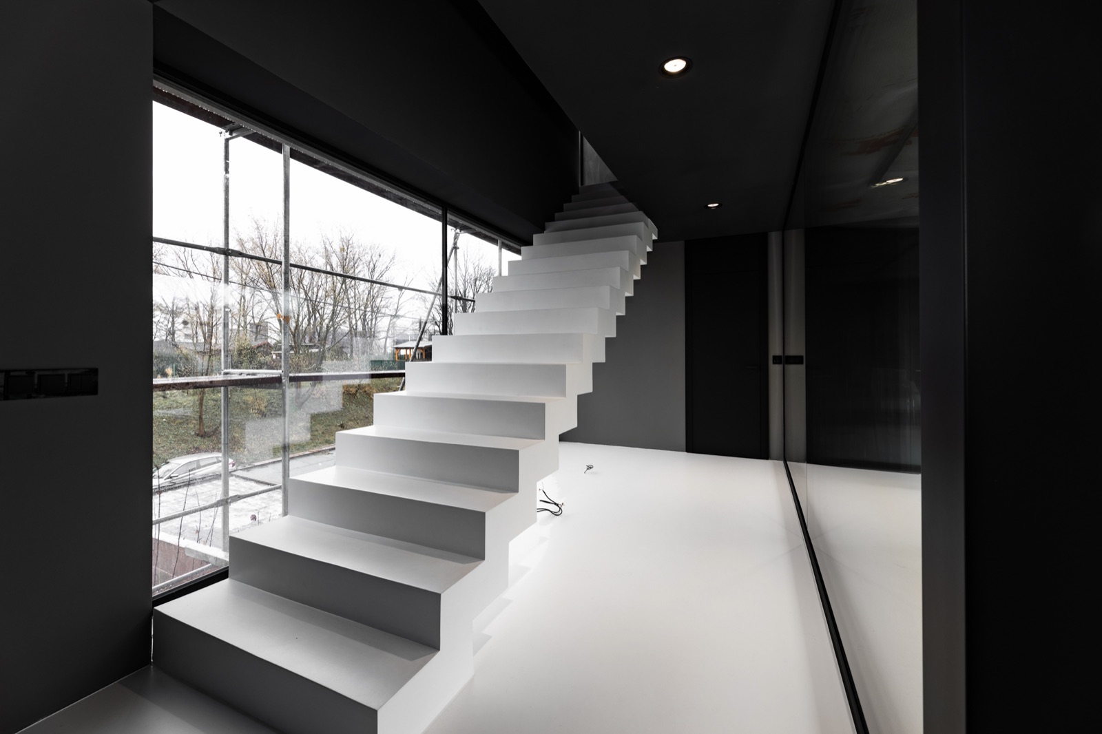 Designové plovoucí schodiště s betonovým vzhledem stěrky, pohled zdola — realizace Dehner
