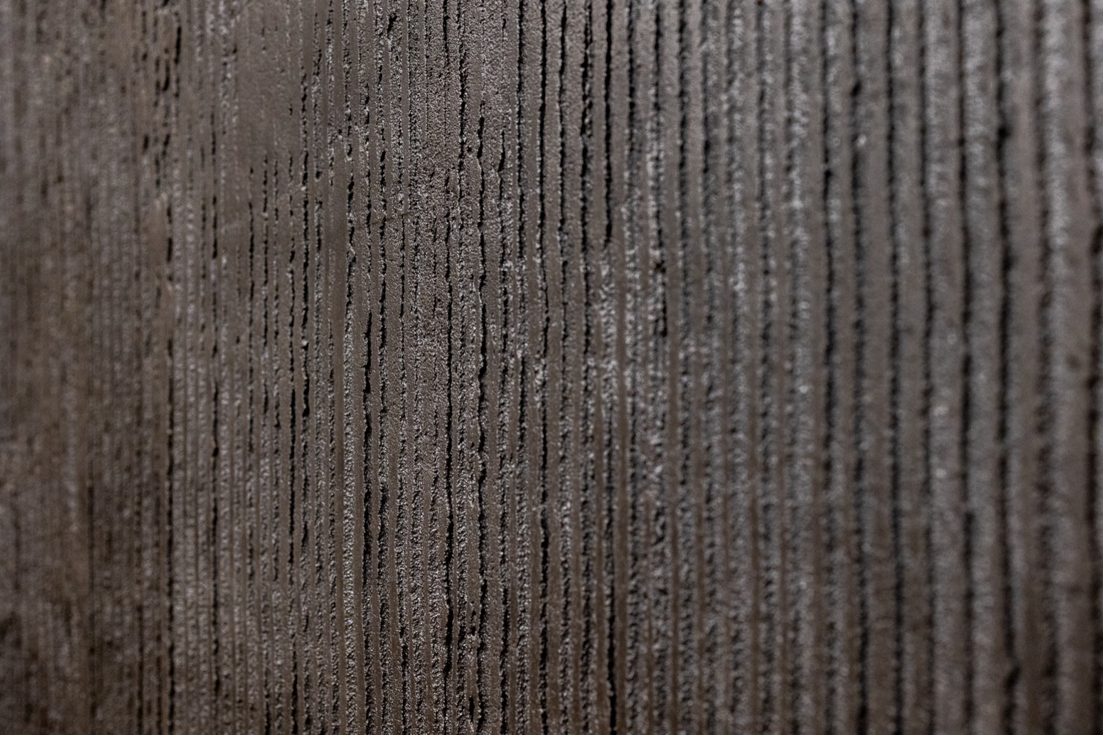 Detail hnědošedé jemně rýhované stěrky, makro struktura — realizace Dehner